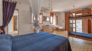 Ein Schlafzimmer mit einem großen Bett, einem Schreibtisch und einem Etagenbett.