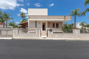 A modern two-story house with a flat roof, a front entrance with steps, and a gated driveway. - 3578 Home In Salento Luna by Barbarhouse (Carpignano Salentino)