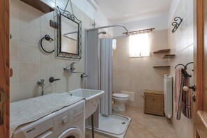 A compact bathroom with a washing machine, a toilet, and a shower enclosure. - 3578 Home In Salento Luna by Barbarhouse (Carpignano Salentino)