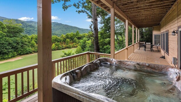 A hot tub on a wooden deck with a view of a golf course and mountains. - 4-Bedroom Mountain House w/Golf Course View, Hot Tub, Pool Table, & Foosball! (Whittier)