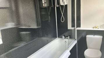 Une salle de bain moderne avec une baignoire sur pieds, des toilettes et un lavabo.