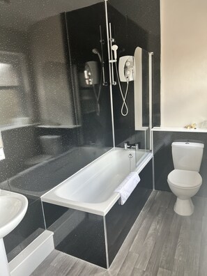 A modern bathroom with a freestanding bathtub, a toilet, and a sink.