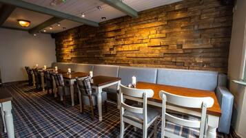 A restaurant interior with a wooden wall, checkered floor, and a seating area with tables and chairs.