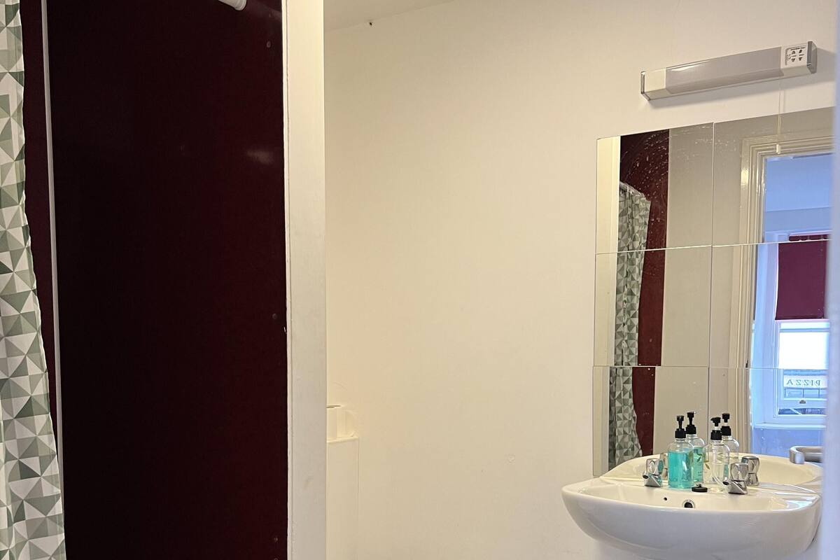 A bathroom with a white sink, a toilet, and a shower curtain.