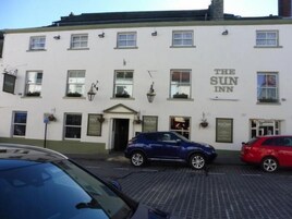 Un edificio con el letrero "The Sun Inn" en la fachada.