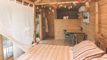 Una habitación de cabaña de madera con una cama, una mesa y una silla.