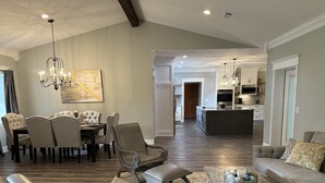 Ein geräumiges Wohnzimmer mit Essbereich, einer Küche und einer großen Kochinsel.