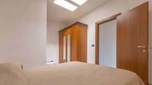 A bedroom with a bed, a wardrobe, and a door. - 3494 Vico Roca by Barbarhouse (Melendugno)