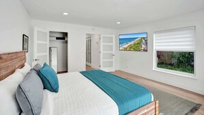 A bedroom with a bed, a view of the ocean, a window with blinds, and a closet with open doors. - Villa Lauren: 4-min walk to beach, off of Atlantic (Delray Beach)