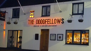 Um edifício com uma placa que diz 'The Oddfellows Public House, E. Cafe Bar & Restaurant'.