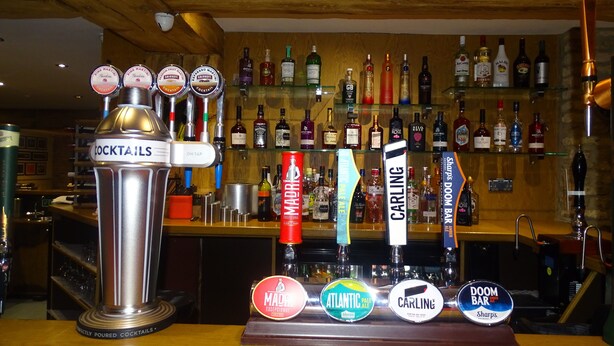 A bar area with a tap labeled "COCKTAILS" and multiple bottles of alcohol behind it. - Oddfellows Hotel Bar & Restaurant (Goole)