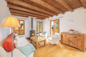 A cozy living room with a fireplace, wooden furniture, and large windows. - Chalet Papin (Riddes)