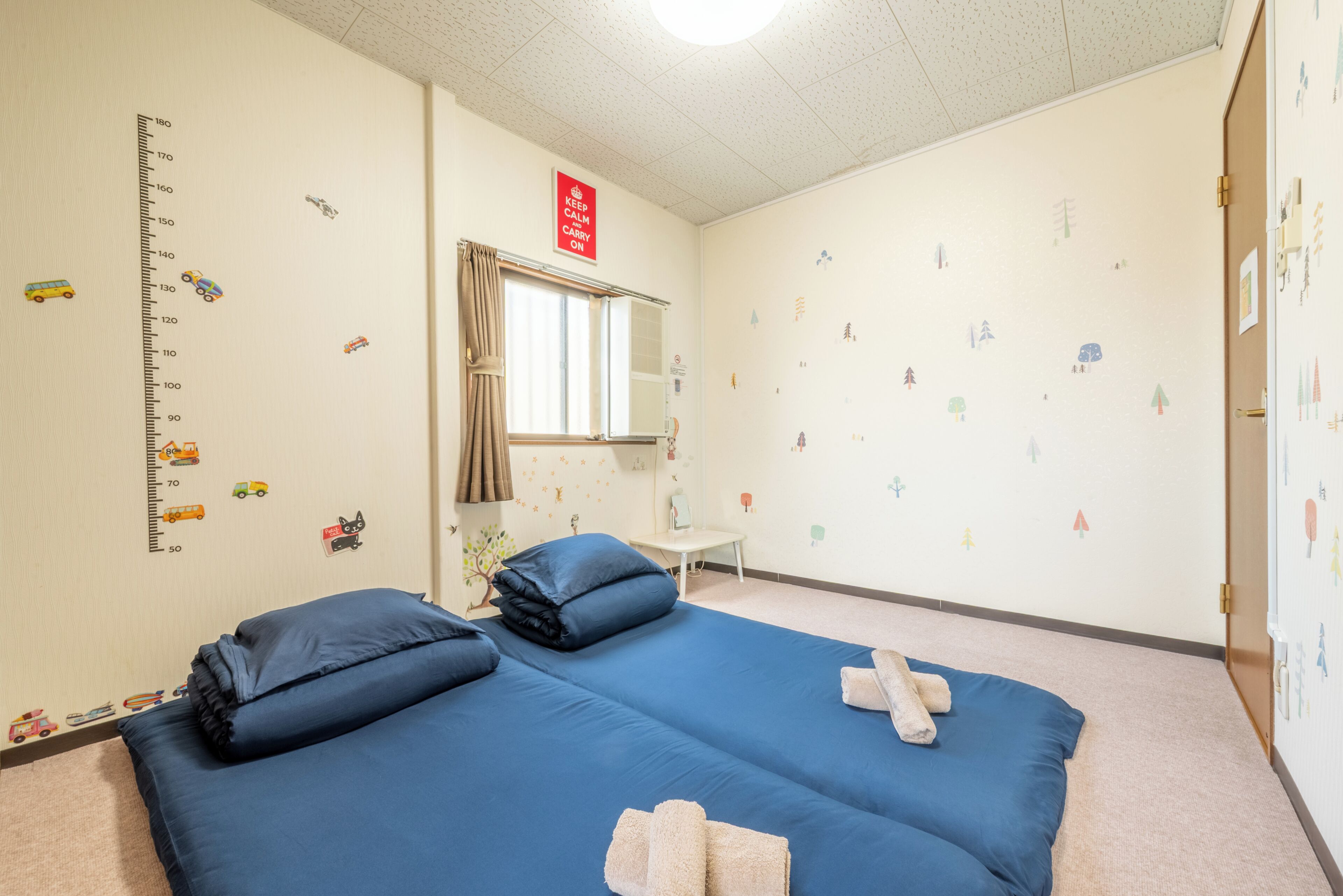 Una habitación con una cama, una ventana, un espejo y adornos en la pared.