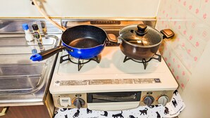 A kitchen with a stove, two pots, a sink, and a faucet. - DoumoTengachaya (Osaka)