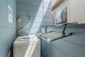 A small bathroom with a toilet, a sink, and a towel rack. - DoumoTengachaya (Osaka)