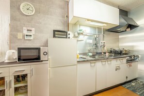 A compact kitchen with a microwave, toaster, and stove. - DoumoTengachaya (Osaka)