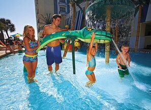 A pool area with water features and lounge chairs.