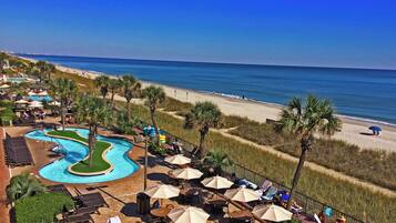Een resort met een zwembad, strand en een terras.