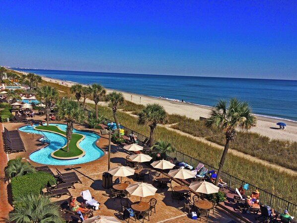 Un resort con piscina, playa y zona de estar al aire libre.