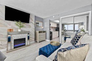 Una sala de estar moderna con chimenea, un sofá y un comedor.