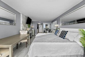 Una habitación de hotel moderna con una cama grande, un escritorio y un televisor.