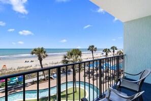 Ein Balkon mit Blick auf Strand und Poolbereich.