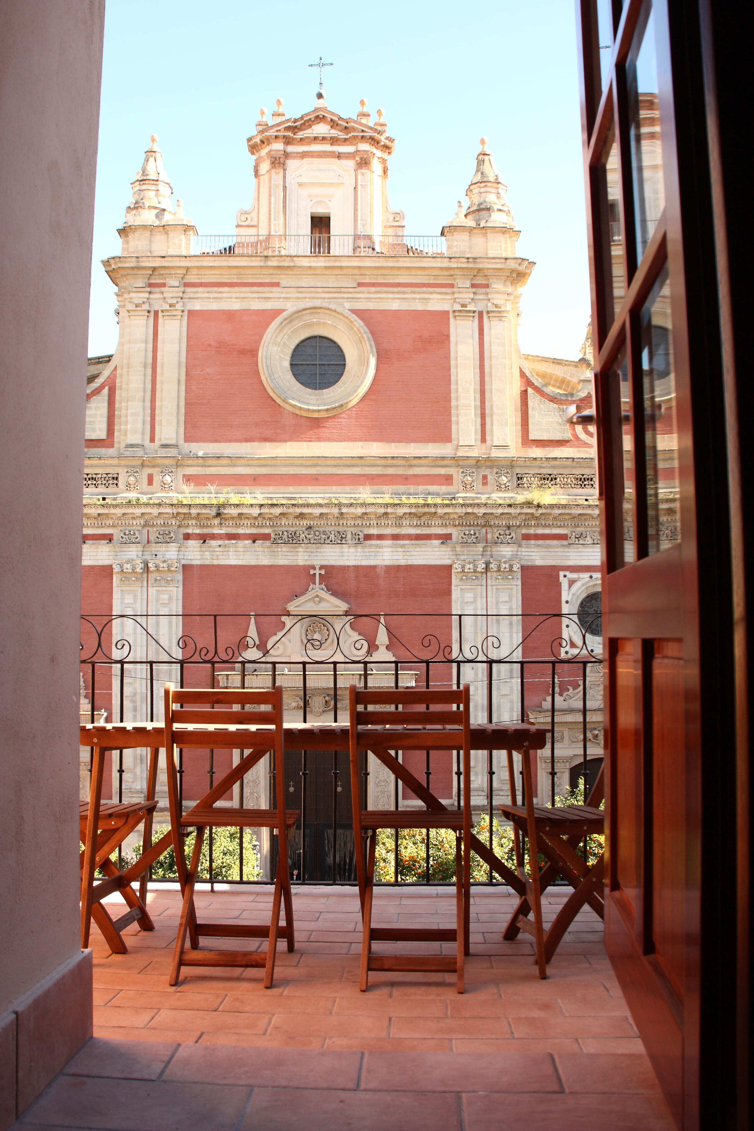 Une vue d’une église dotée d’un clocher et d’un balcon avec des chaises en bois.