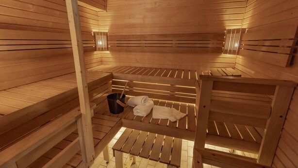 A sauna with wooden benches and benches, a bucket, and towels. - Södergården Åre (Undersaker)