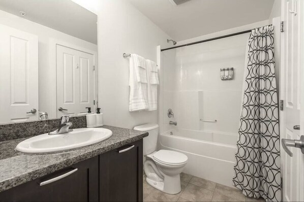 A bathroom with a sink, toilet, and bathtub.