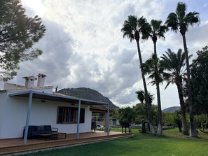 A house with a patio, outdoor furniture, and a view of a hill.