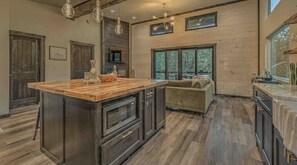 Enjoy cooking in this well-equipped kitchen with a central island and large windows offering views of the surrounding landscape.