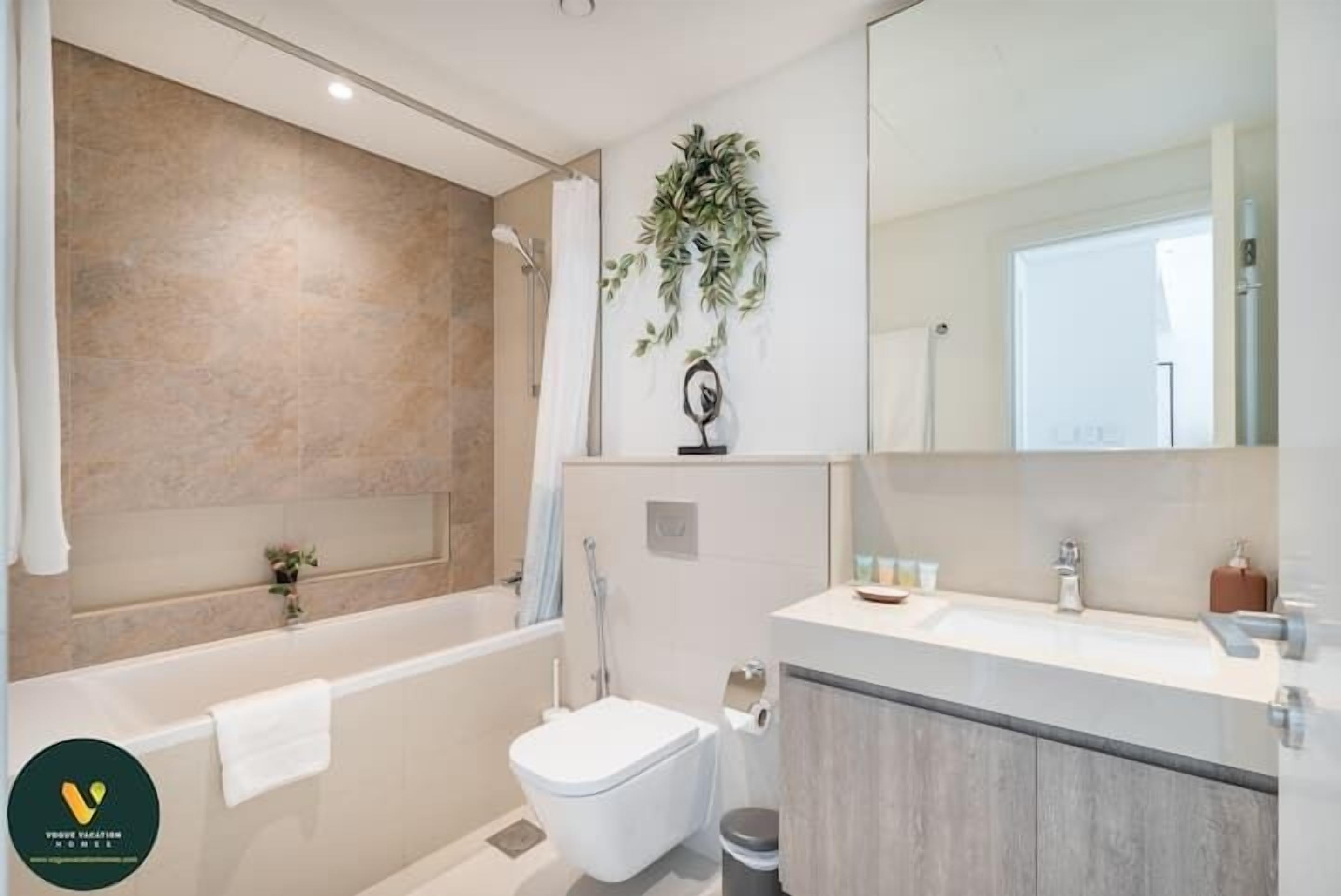 A modern bathroom with a bathtub, toilet, and sink.