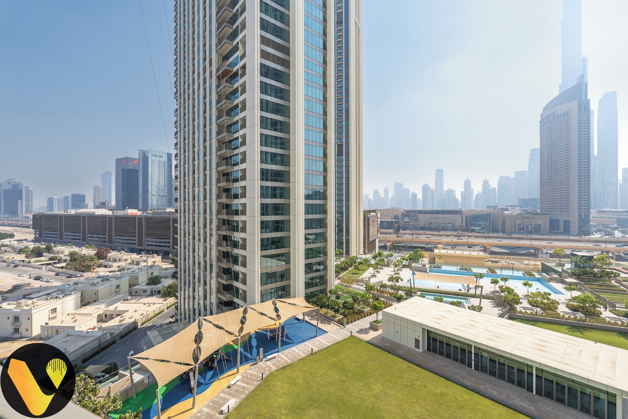 A high-rise building with a modern design, surrounded by other tall buildings and a cityscape in the background.