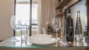 A dining table with wine glasses, plates, and bottles, set in a room with a view. - Estúdio Aconchegante, Metrô, Piscina, Sauna, AC (São Paulo)