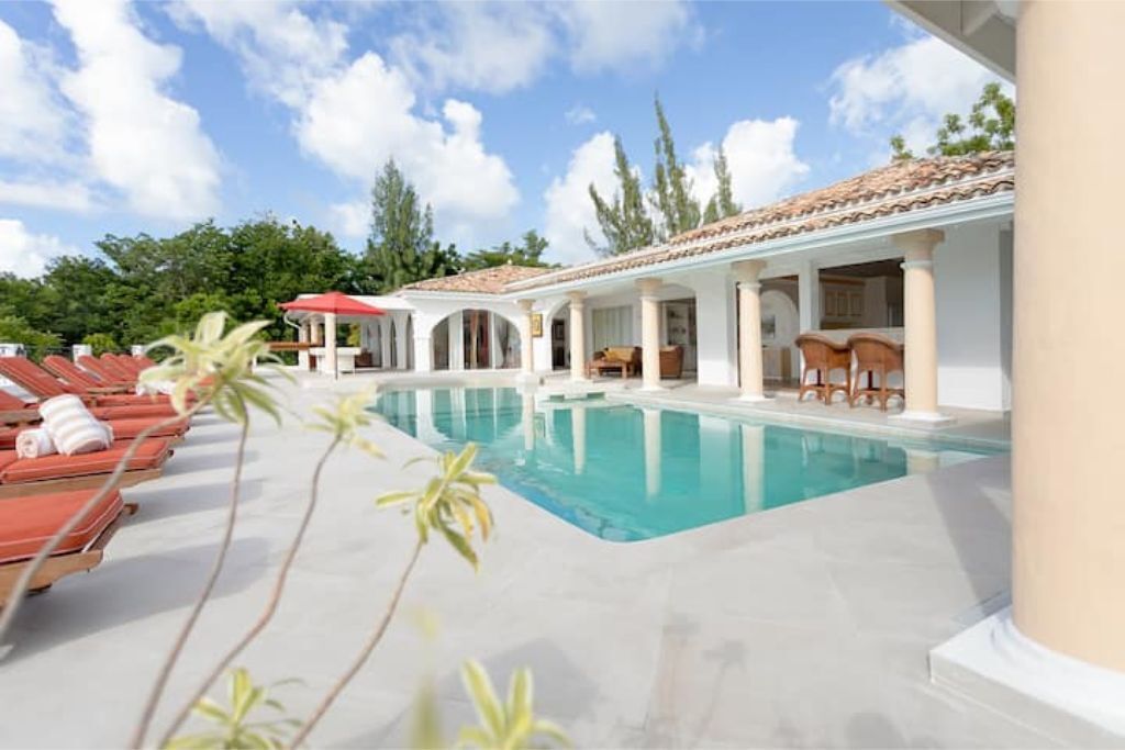 Ein Poolbereich mit Liegestühlen und einer überdachten Lounge.