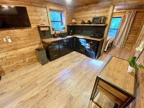 Køleskab, kaffe-/temaskine, køkkentøj/tallerkener/redskaber, spisebord