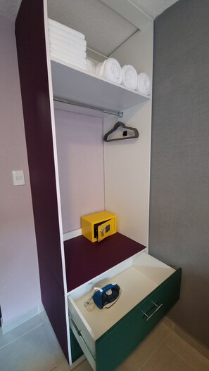 Cozy retreat with a wardrobe and green drawer unit.