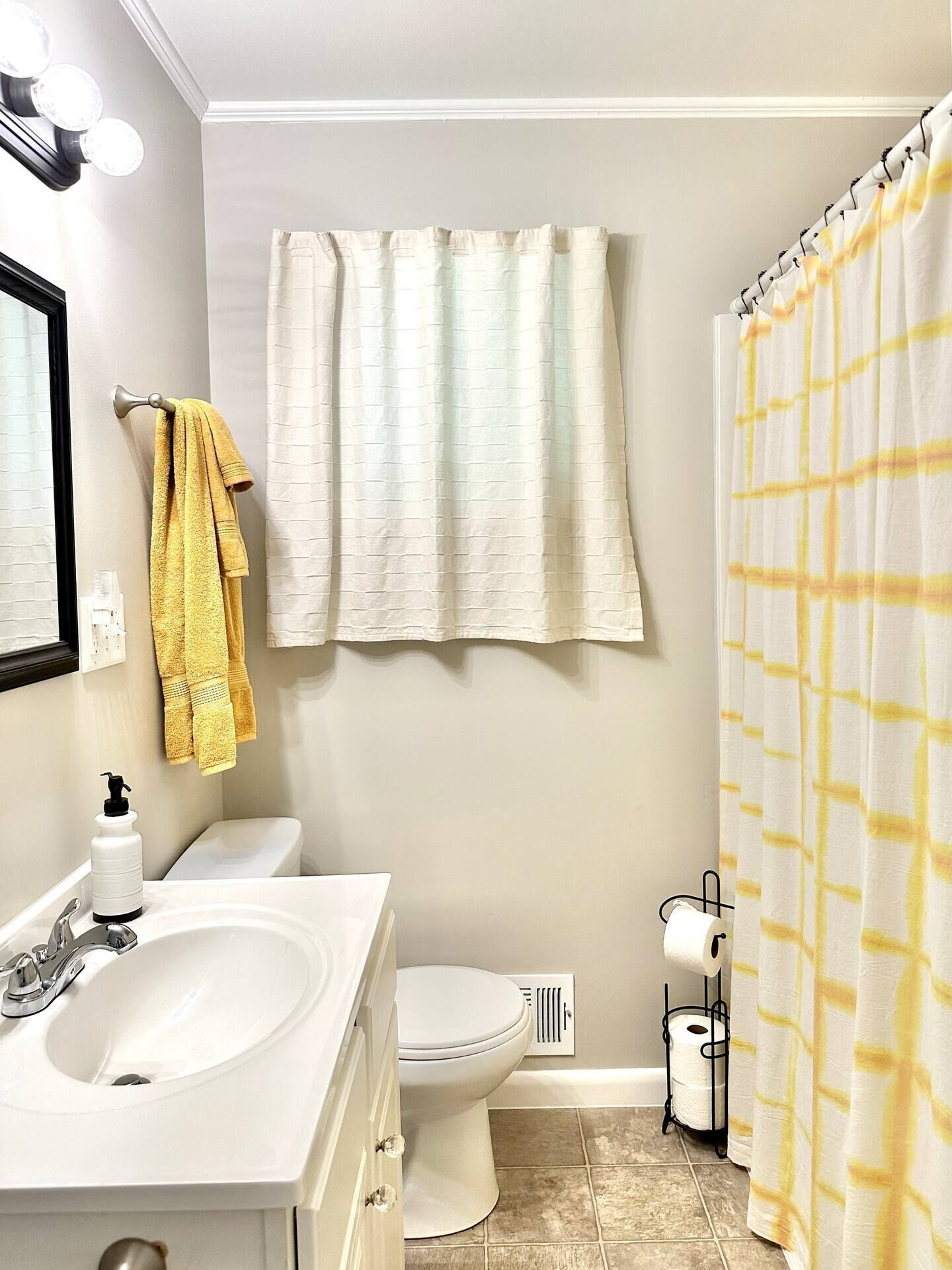 A bathroom with a white sink, a toilet, and a shower curtain.