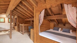 Acogedora habitación de cabaña de madera con una cama, una silla y una mesita.