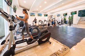 A gym with treadmills, elliptical machines, and weight equipment. - The Sens Riviera By Oasis (Akumal)