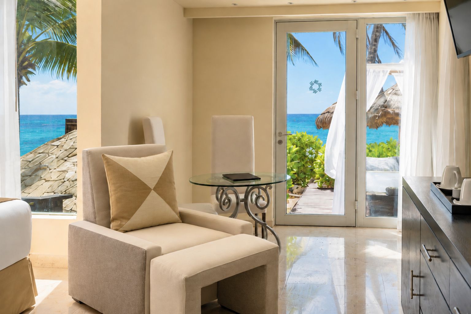 Ein Zimmer mit Meerblick, einem Glastisch und einer Couch mit Kissen.