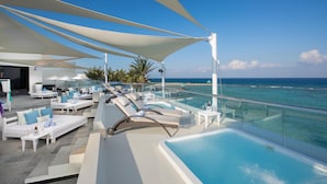 A luxurious outdoor lounge area with sun loungers, a small pool, and a clear view of the ocean. - The Sens Riviera By Oasis (Akumal)