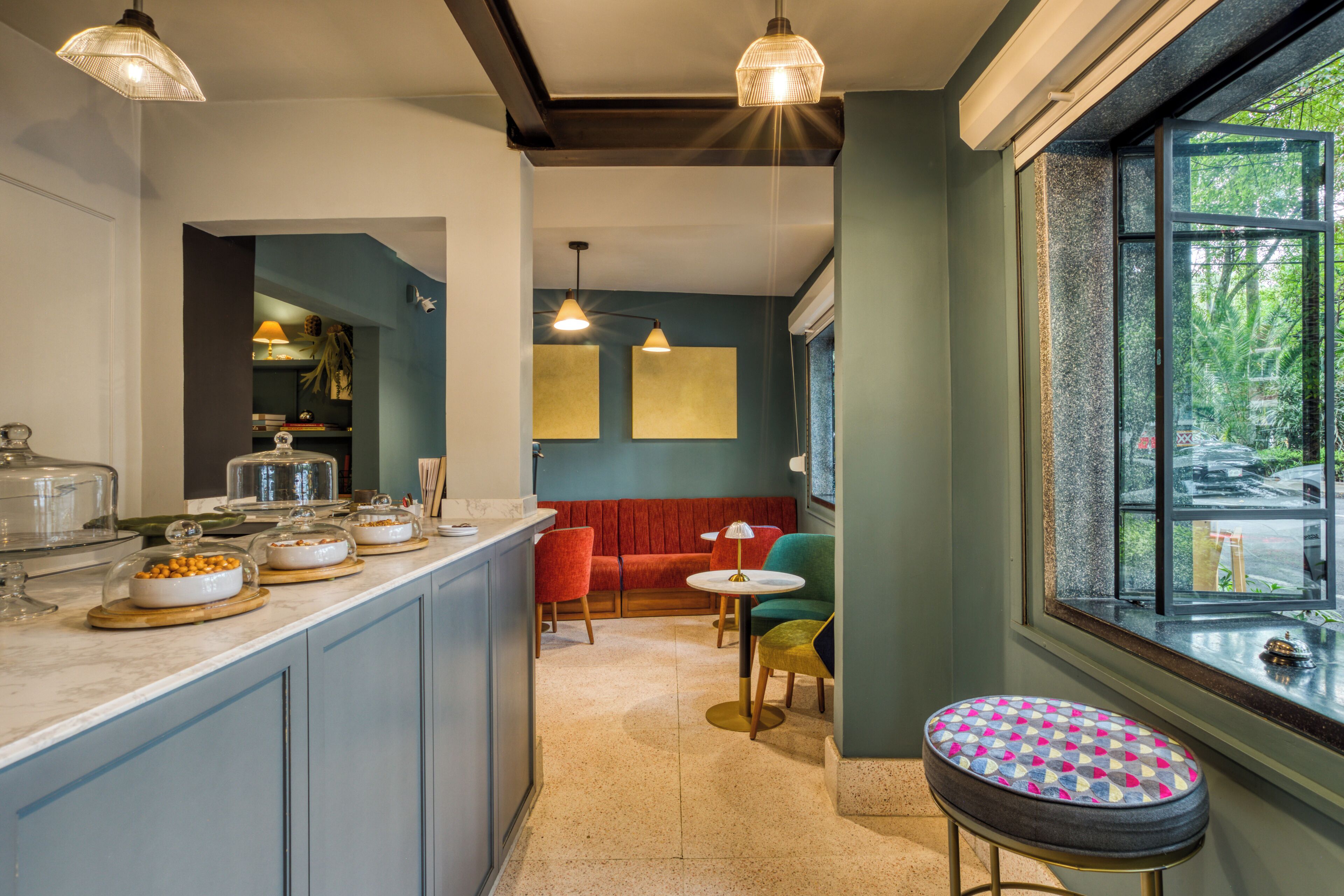 A kitchen with a bar area, a dining space with chairs, and a large window with a view.