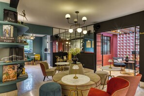 Ein modernes Interieur mit runden Tischen, Stühlen und einem Bücherregal mit Büchern und Dekorationsobjekten.