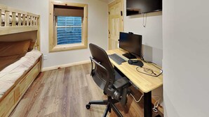A compact bedroom with a bunk bed, a desk with a computer, and a window with blinds. - Moon and Stars by Taylor Made Deep Creek (McHenry)