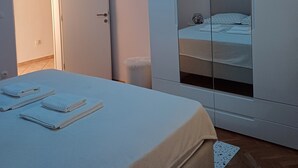 A bedroom with a bed, a wardrobe, and a ceiling light.
