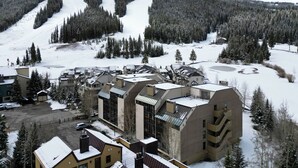 Ein schneebedecktes Skigebiet mit modernen Gebäuden und einer Skipiste.