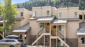 A multi-story building with a flat roof, a central staircase, and a mountain backdrop. - Cozy Vail Retreat, On Shuttle Route, BBQ (Vail)