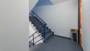 Un escalier avec des rampes bleues menant à un palier.