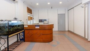 Un espace d’accueil comprenant un comptoir de réception, un aquarium et un sol carrelé.